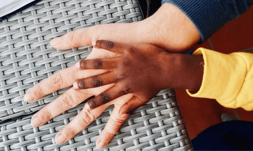 Little Child's hand on adoptive parent's hand